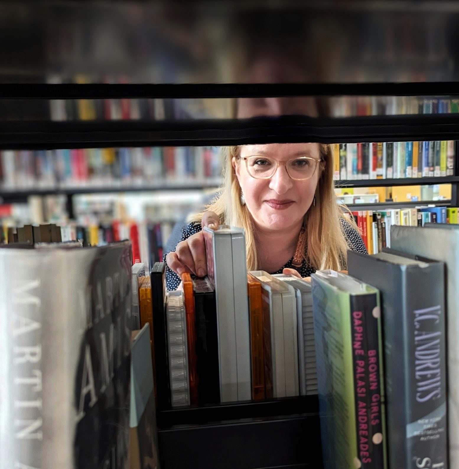 Photo of library officer looking through shelves Photo of library officer looking through shelves