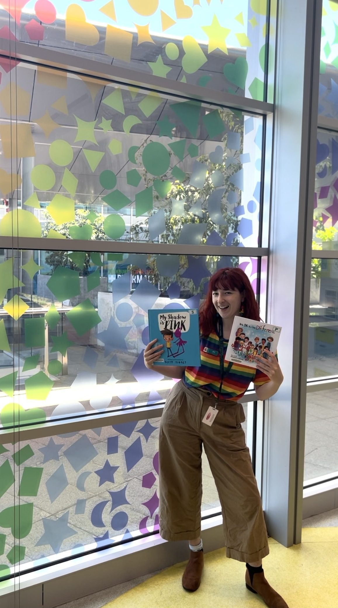 Photograph of library officer with window artwork Photograph of library officer with window artwork